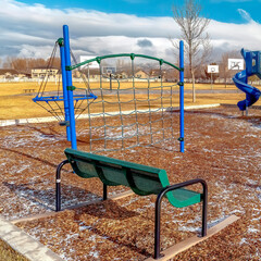 Square frame Playground and benches on a park with view of homes and basketball courts