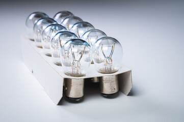 New incandescent car lamps for car sizes in paper-packed lot on a grey gradient background