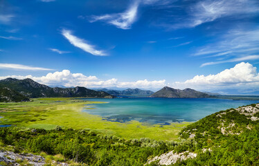 Fototapeta premium Montenegro Skadar Lake beautiful scenic coast national park panorama. Blue sky water reflection sunny outdoor Mediterranean summer wonderland background. European tourism vacation concept