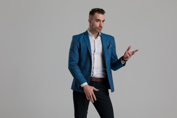confident young man looking and presenting to side