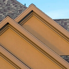 Square House exterior with front gable roof design against blue sky background