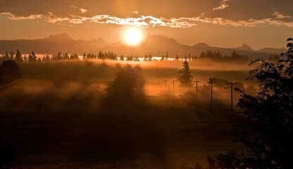 Stunning sunrise landscape sun coming over the mountain known as 3 Sisters or 3 Fingers (called...