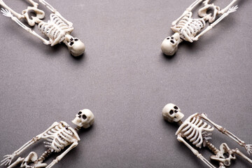 skeletons lie heads towards each other facing the center of the gray background. tragic deadly...