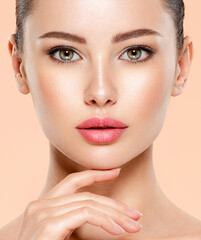 Portrait of beautiful  girl which touching her fresh face.  Closeup face of young woman with clean...