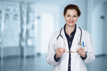 Female doctor with glasses in hands .