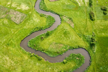 Aerial view landscape of winding river in green field.