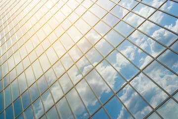 Dirty windows of a newly built office building reflecting the blue sky with clouds. Clouds reflected in windows of modern office building.