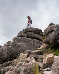 young man standing on a big rock