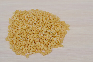 Scattered macaroni shells. Quarantine food supplies. Food stocks. Crisis. Food delivery, donations. A copy of the space. Space for text.