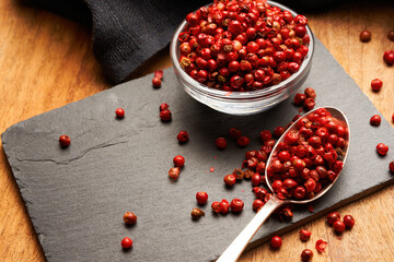 Pimienta roja en cucharilla sobre pizarra negra
