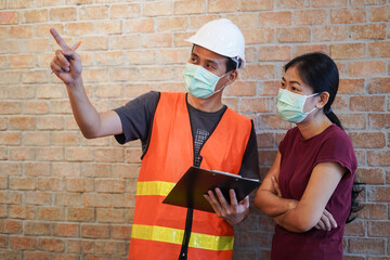 Worker or inspector in protective mark discuss with customer and inspect advice by checklist and...