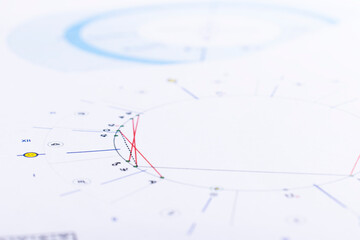 The desktop of an astrologer. The magical mysterious atmosphere of the working environment of the predictor of the future. Printouts of astrological charts and tables scattered across the table.