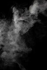 A stream of white smoke on a black background mixes randomly creating bizarre swirl patterns