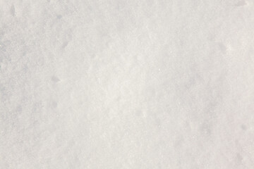 White snow on the ground on a clear sunny day. Snow texture