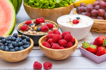 Group Fruits mixed and vegetables with salad bowl, nuts bowl, strawberry, banana, and pineapple, orange juice,  vitamin c in food  nature for health and diet in the top view on the wood table.