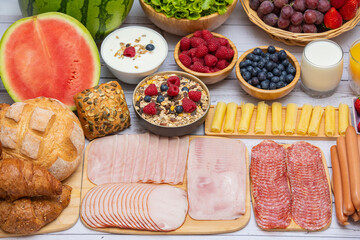 Obraz na płótnie Canvas Breakfast in the morning on the table with vegetable,Croissant bread, Bacon, ham, cheese, lettuce, beans, corn flakes and fruits for healthy breakfast Top view with copy space