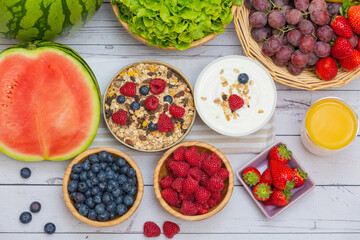 Group Fruits mixed and vegetables with salad bowl, nuts bowl, strawberry, banana, and pineapple, orange juice,  vitamin c in food  nature for health and diet in the top view on the wood table.