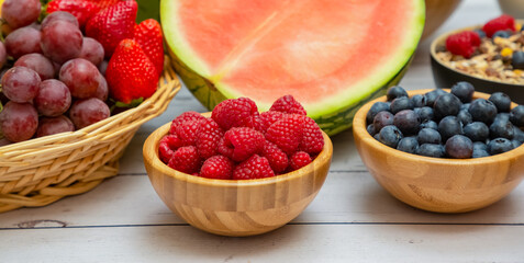 Group Fruits mixed and vegetables with salad bowl, nuts bowl, strawberry, banana, and pineapple, orange juice,  vitamin c in food  nature for health and diet in the top view on the wood table.
