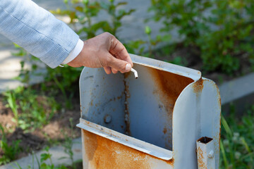 man throw the cigarette in the trash