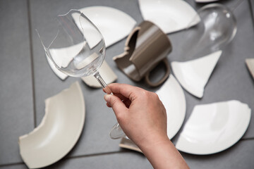 Broken Plate or broken water glass and dishes on the floor in the kitchen room The concept of...