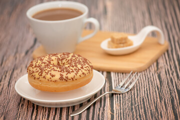 Dessert, Donuts, chocolate and strawberry circles, sugar and cream on Donuts and hot coffee cups, preparation for a break or party on the wooden table background.