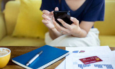 Close up. woman using mobile phone shopping online while she work from home