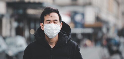 The image face of a young Asian man wearing a mask to prevent germs, toxic fumes, and dust....