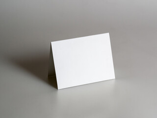 Blank, paper, white card for your design on a gray background. Mock-up. Stylized stock photos.