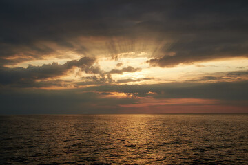bright and mystic sunset with bright colors and a cloudy sky over the sea