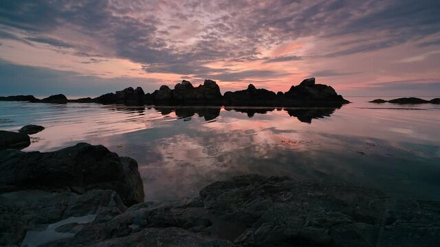 Video with colorful sunrise sky at rocky coastline and calm summer sea, the Black Sea coast, Bulgaria