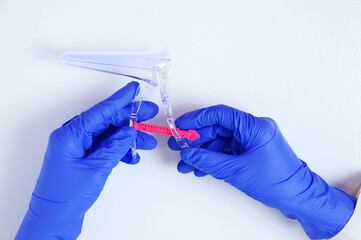 Gynecologist doctor with a gynecological mirror in his hands on a white background.