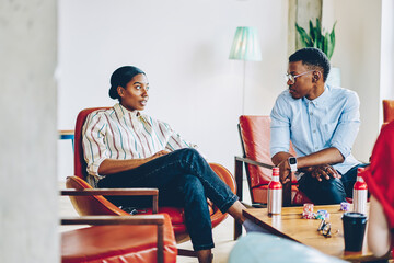 Black male and female friends chatting at living room