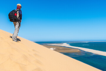 Tourist admiring the view from a sand dune at Sandwich Harbour