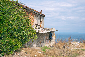 Fragments of old buildings against the backdrop of a cloudy summer sky and sea.