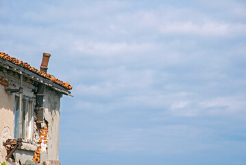 Fragments of old buildings against the backdrop of a cloudy summer sky and sea.