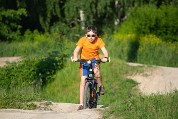 Fototapeta na wymiar Teen cyclist riding on hilly terrain