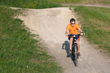 child riding a bike on a dirt road