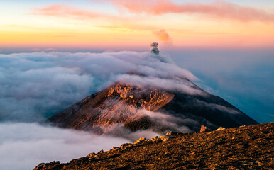 Sunrise with clouds rolling over the summit of Volcan de Fuego in Guatemala seen from the peak of Acatenango.