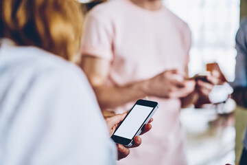 Woman interacting with modern smartphone in office