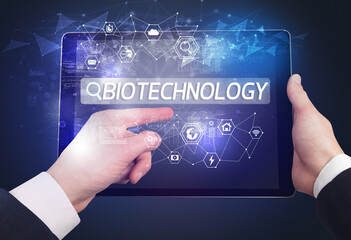 Close-up of a tablet searching BIOTECHNOLOGY inscription, hi-tech computing concept