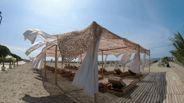 Suumer vacation luxury resort white tent on a sandy beach against the background of blue sunny sky