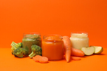 Composition with vegetable puree on orange background. Baby food
