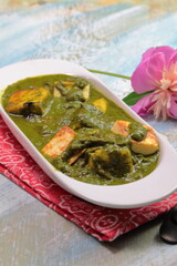A bowl of Palak Paneer made of Paneer cheese dipped in mildly spiced Spinach gravy.