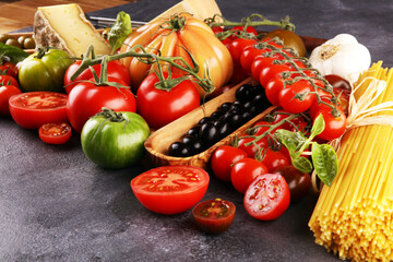 Tomatoes, Pasta, vegetables, herbs and spices for Italian food on rustic table