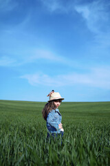 Naklejka na ściany i meble Cute girl in a green field