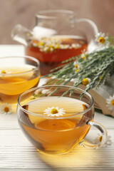 Composition with chamomile tea on white wooden background