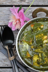 A bowl of Palak Paneer made of Paneer cheese dipped in mildly spiced Spinach gravy.