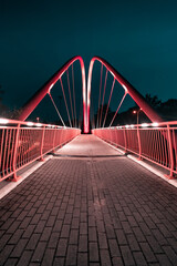 Bydgoszcz by night. The famous bicycle footbridge over the University route in night city lights.