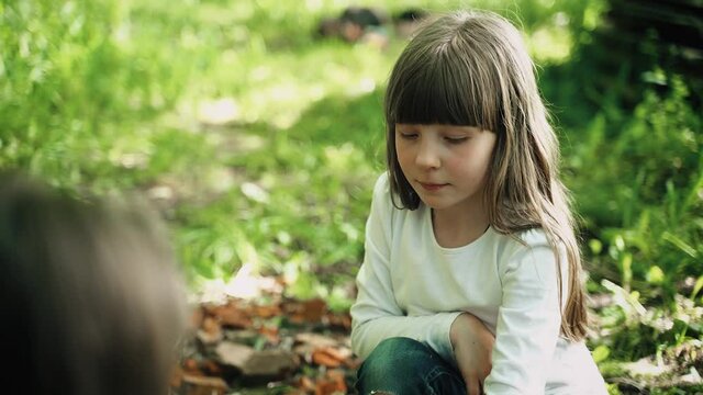 Picnic in the spring forest with a snack. Girl frys a piece of bread on a wooden twig on the grill