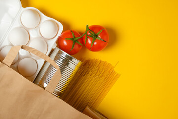 Food donations on a yellow background. Social assistance. Copy space.